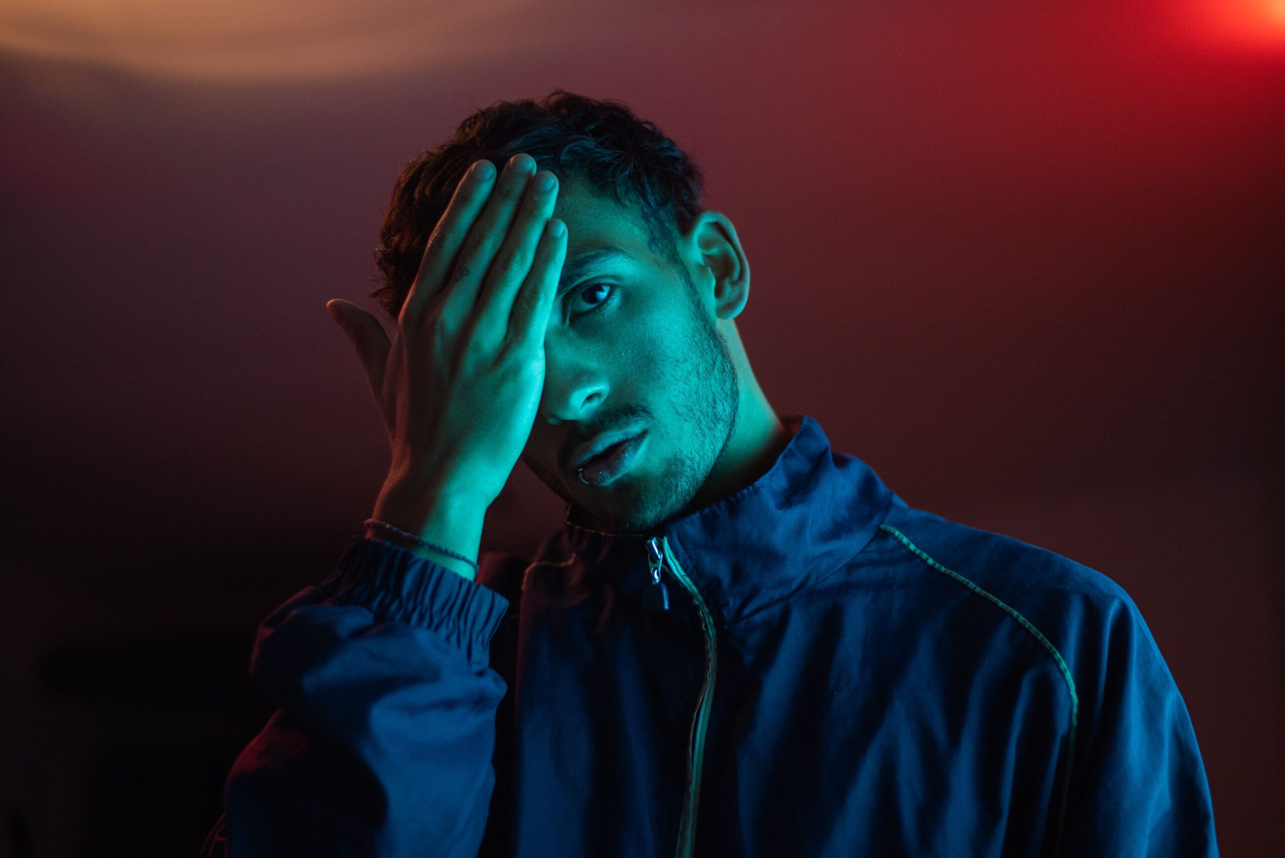 A thought-provoking portrait of a man in neon lighting, capturing mood and expression.